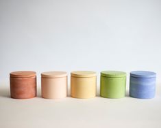 four different colored jars are lined up in a row