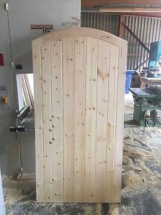 a large wooden door in the middle of a room with other tools and machinery behind it