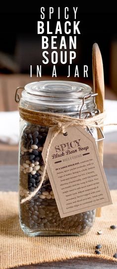 a jar filled with black beans sitting on top of a table