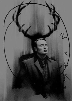 a black and white photo of a man in a suit with antlers on his head