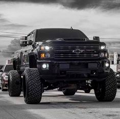 a large black truck driving down a street