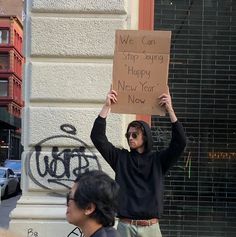 a man holding up a sign that says we can stop saying happy new year now