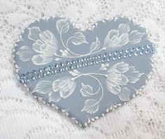 a heart shaped box with blue and white flowers on it