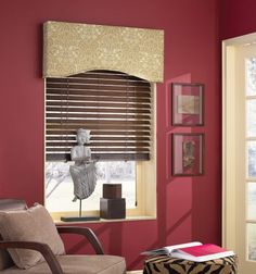 a living room with red walls and furniture, including a chair in front of the window