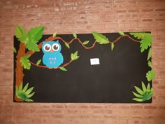 an owl sitting on a tree branch in front of a blackboard with leaves and branches