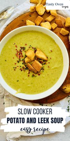 a bowl of potato and leek soup with croutons on the side next to it