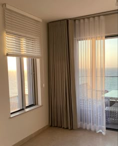 an empty room with large windows overlooking the ocean