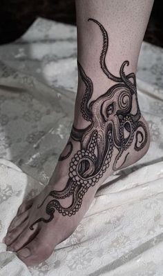 an octopus tattoo is on the foot of a person with black ink and white laces