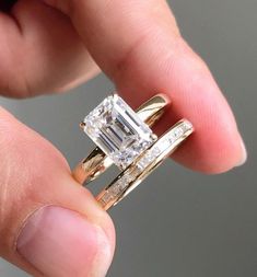 a person holding an engagement ring in their left hand with the diamond on it's side