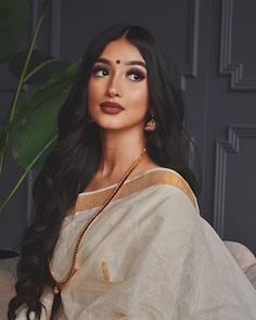 a woman with long black hair wearing a white sari