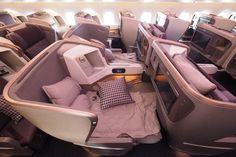 the inside of an airplane with lots of seats and pillows on it's sides