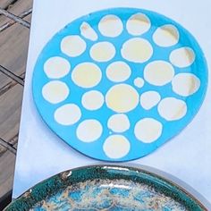 a blue and white plate sitting on top of a table next to a metal pan