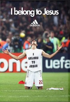 a man standing on top of a soccer field holding his hands up in the air