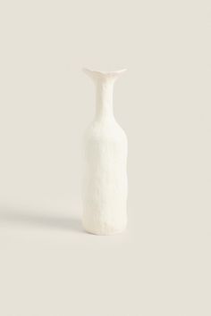 a white vase sitting on top of a table