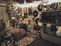 a room filled with lots of stuff animals and record records on the wall next to a bed