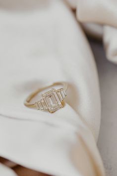 a diamond ring sitting on top of a white cloth