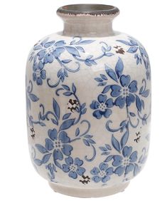 a blue and white vase with flowers painted on the outside, sitting in front of a white background