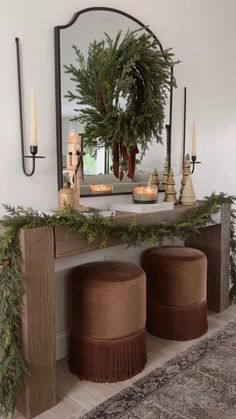 a mirror and two stools in front of a table with christmas decorations on it