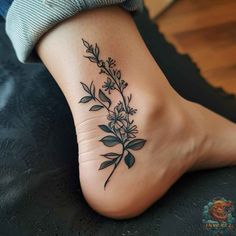 a tattoo on the foot of a woman with flowers and leaves growing out of it