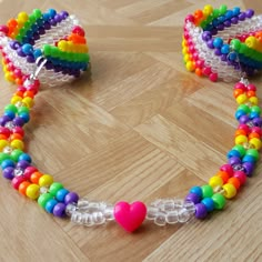 a bracelet made out of plastic beads with a heart on the clasp and bead ends