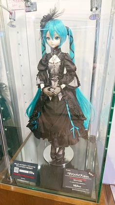 a doll with blue hair in a glass case