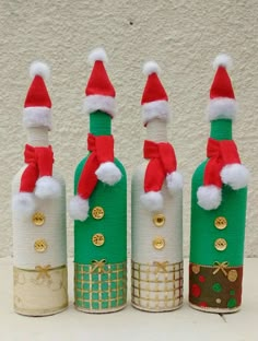 three wine bottles decorated with santa hats and gold trimmings are sitting next to each other