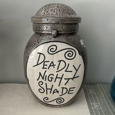 a ceramic jar with the words deadly night shade painted on it