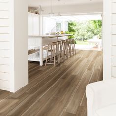 an open kitchen and dining room with wood floors, white walls and wooden flooring