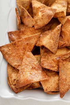 a white plate topped with cut up pieces of breaded tortilla wedges