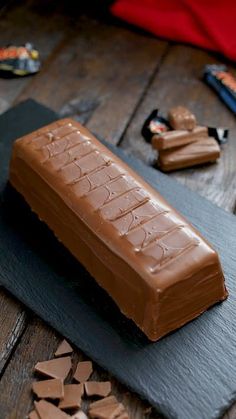 a chocolate bar sitting on top of a cutting board next to some pieces of chocolate