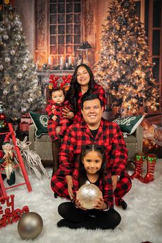 a family posing for a christmas photo in front of a tree