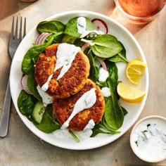 a white plate topped with crab cakes and spinach