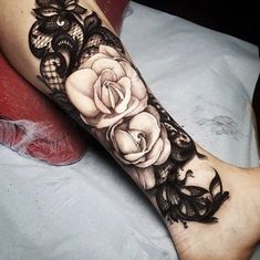 a woman's leg with black lace and roses on it