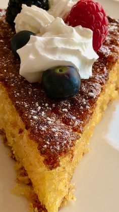 a piece of cake with whipped cream and berries on top