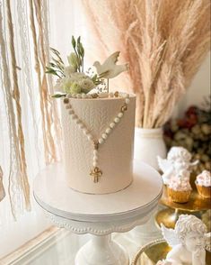 a white cake with pearls and flowers on top