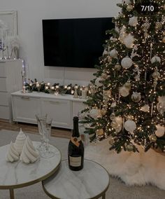 a living room with a christmas tree in the corner and a bottle of wine on the coffee table