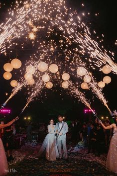 the bride and groom are surrounded by fireworks