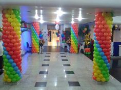 there are many balloons on the floor in this hallway that is decorated with rainbow colors