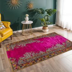 a living room with green walls and pink rug on the floor, two yellow chairs