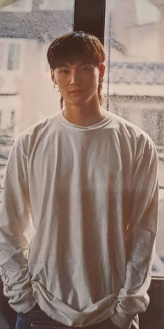 a young man standing in front of a window