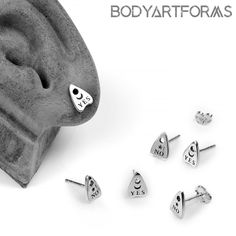 four pairs of heart shaped studs are shown in front of a white background with the words body art forms written on them