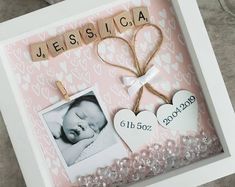 a baby's photo frame with hearts and a name tag attached to it