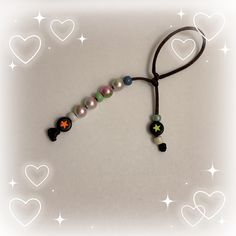 a necklace with beads and stars on it is laying in the shape of a heart