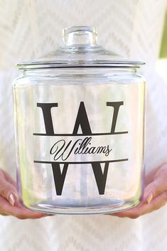 a person holding a glass jar with the word w on it