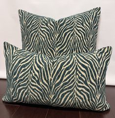 two zebra print pillows sitting on top of a wooden floor