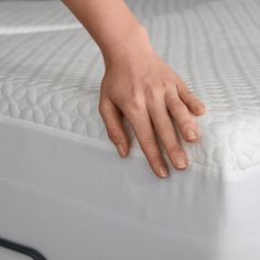 a person's hand on top of a mattress