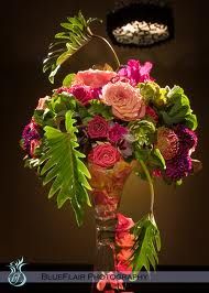 a vase filled with lots of flowers on top of a table