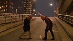 two people standing in the middle of an empty street with traffic cones on their heads