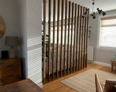 a living room with wooden slats on the wall and a rug in front of it