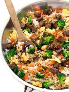 a pan filled with rice, broccoli and beef